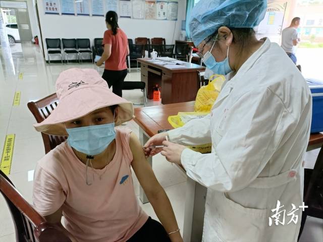 醫(yī)護(hù)人員為村民接種疫苗。