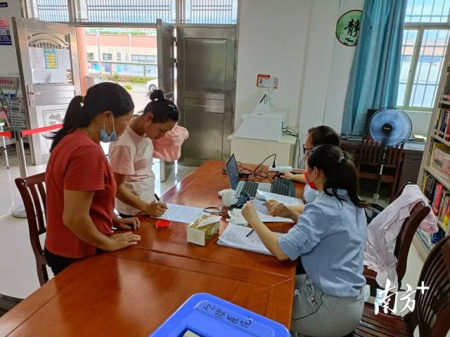 鎮(zhèn)、村干部為村民進(jìn)行接種信息錄入。