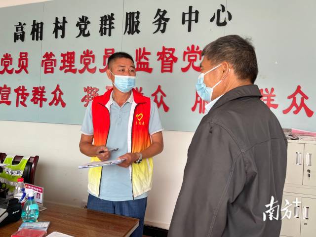 正在為群眾辦事的沈家江（左）。