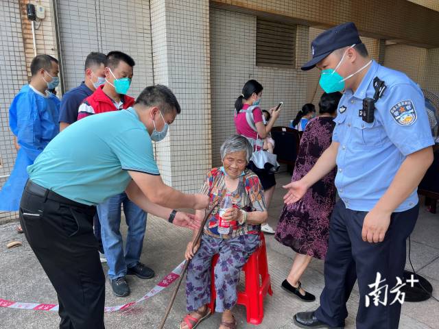 連州市委常委、副市長、九陂鎮(zhèn)黨委書記綦鴻偉在核酸檢測現(xiàn)場協(xié)助老人參加核酸檢測，為老人做好防暑措施。